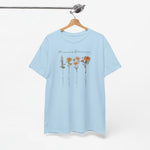Lichtblauw T-shirt aan houten hanger met bloemenprint op de borst