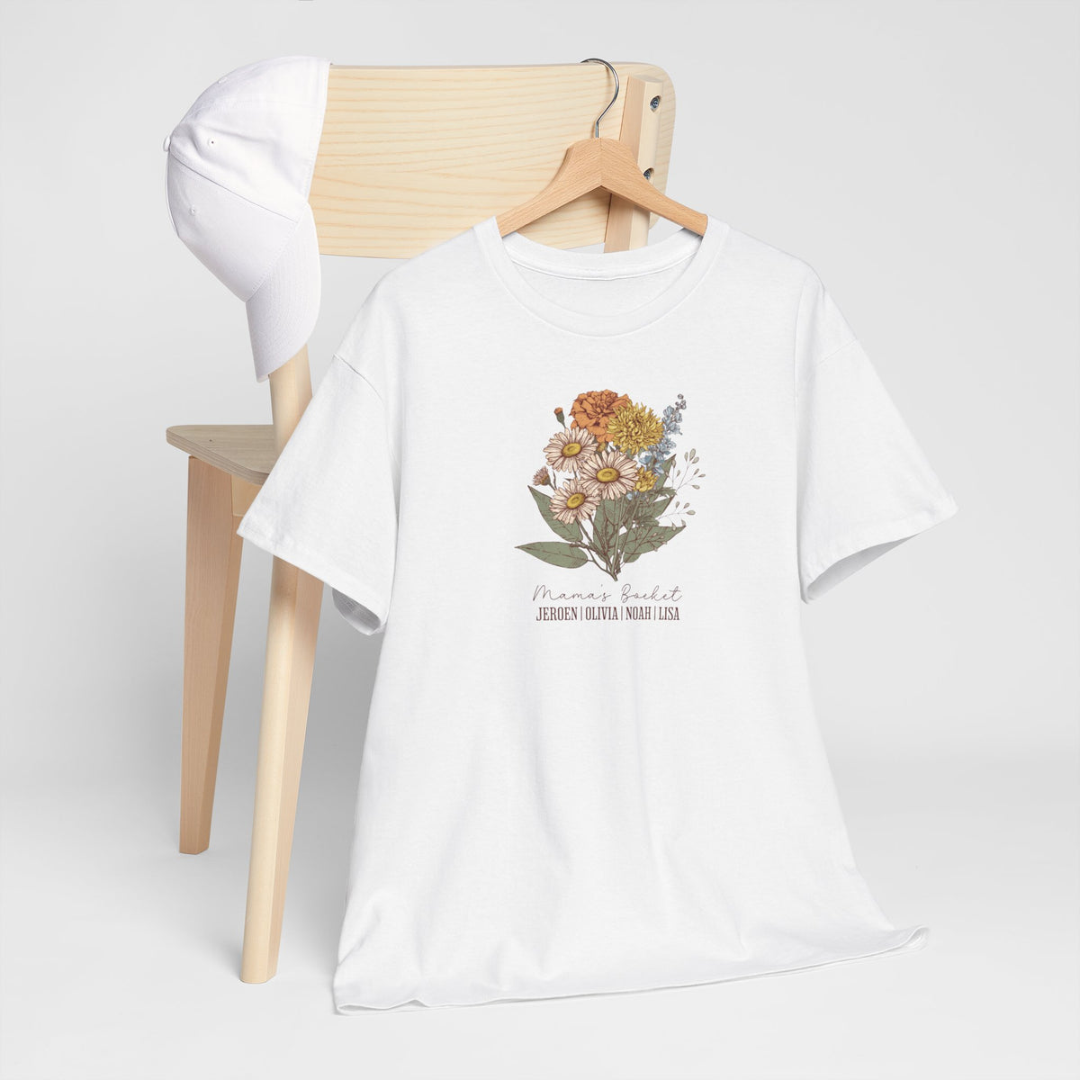 Wit T-shirt op kledinghanger met bloemenboeketprint en kleine naamtekst onderaan.