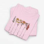 Lichtroze T-shirt met bloemenillustratie en sierlijke namen langs de bloemenstelen.