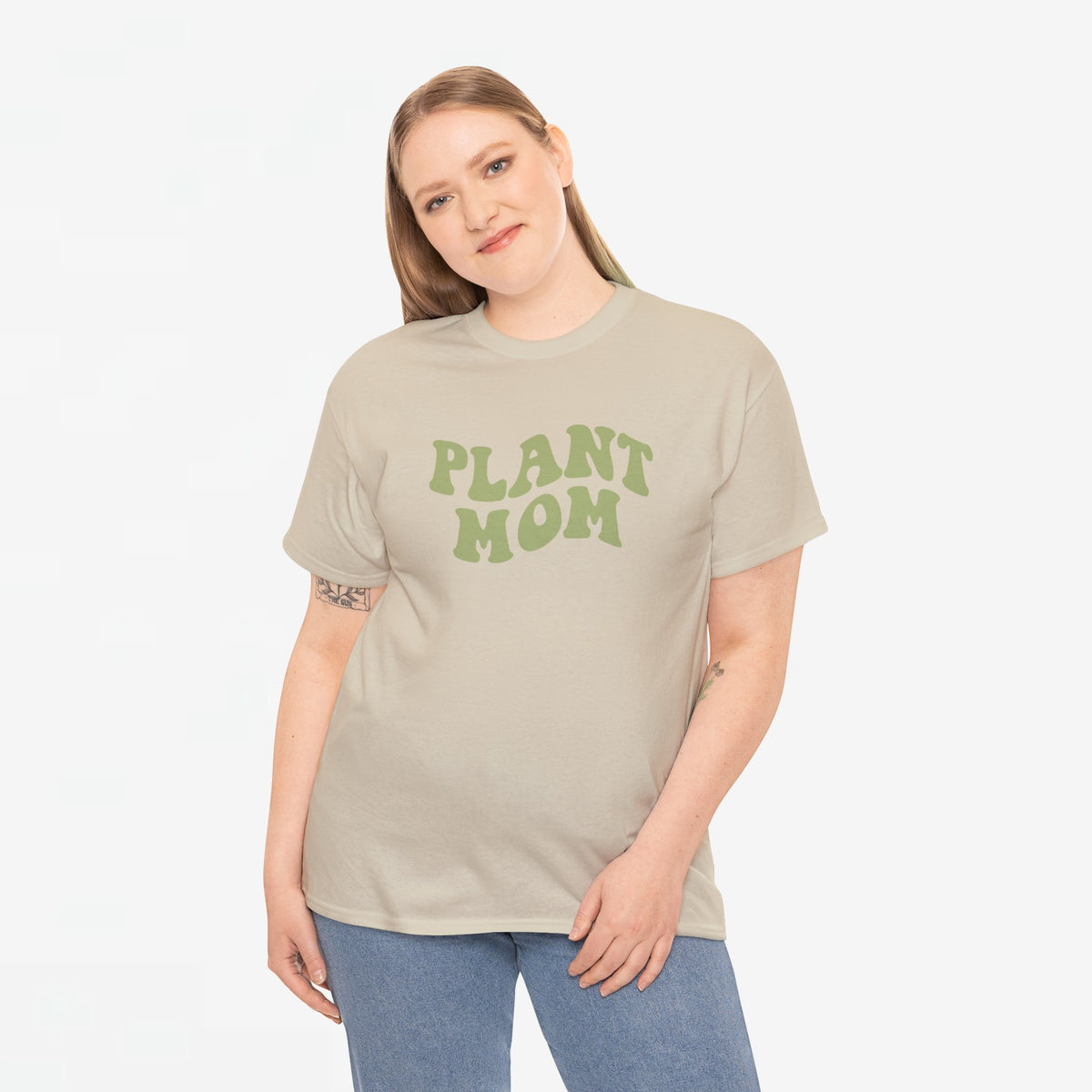 Beige T-shirt met groene “PLANT MOM”-opdruk, gedragen met spijkerbroek.