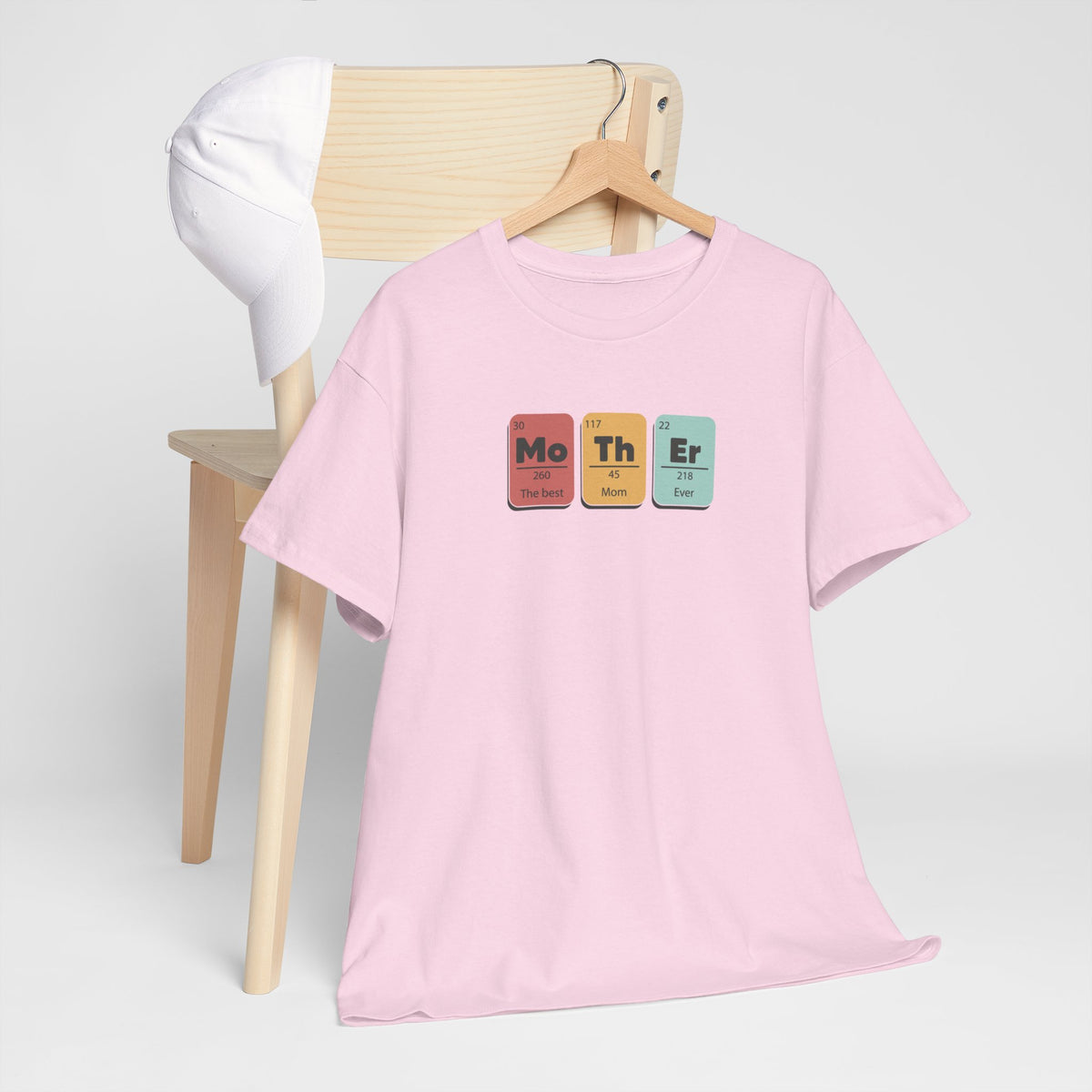 Roze T-shirt op houten hanger met borstprint van gekleurde blokken “Mo Th Er”