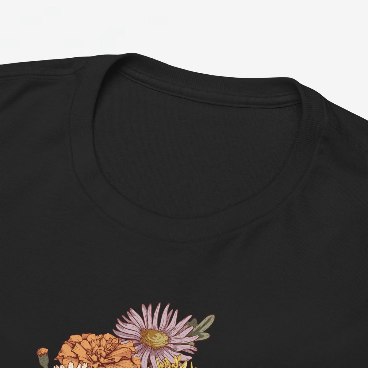 Zwarte t-shirt met ronde hals; close-up van bloemenboeketprint onder de kraag.