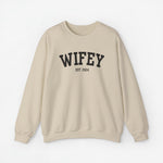Beige sweater met opdruk 'WIFEY' en 'EST. 2024'.