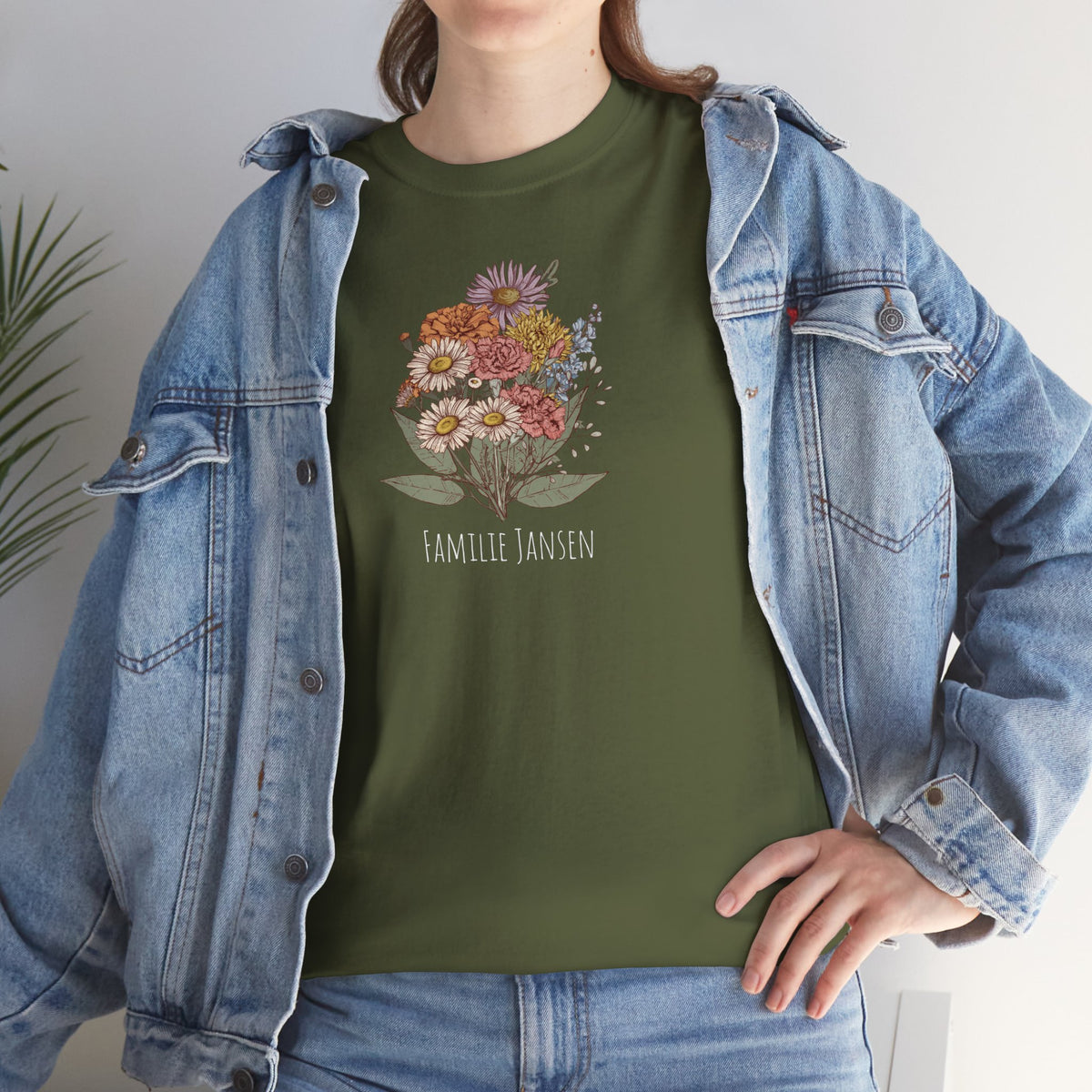 Legergroene T-shirt met bloemenprint en tekst, gecombineerd met blauwe spijkerjas.