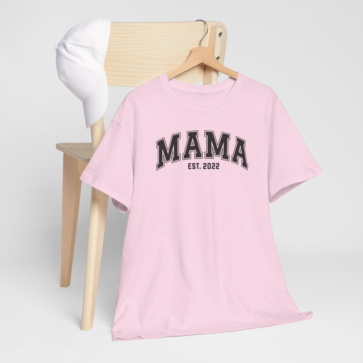 Roze t-shirt met “MAMA” en “EST. 2022” op de borst, op kleerhanger