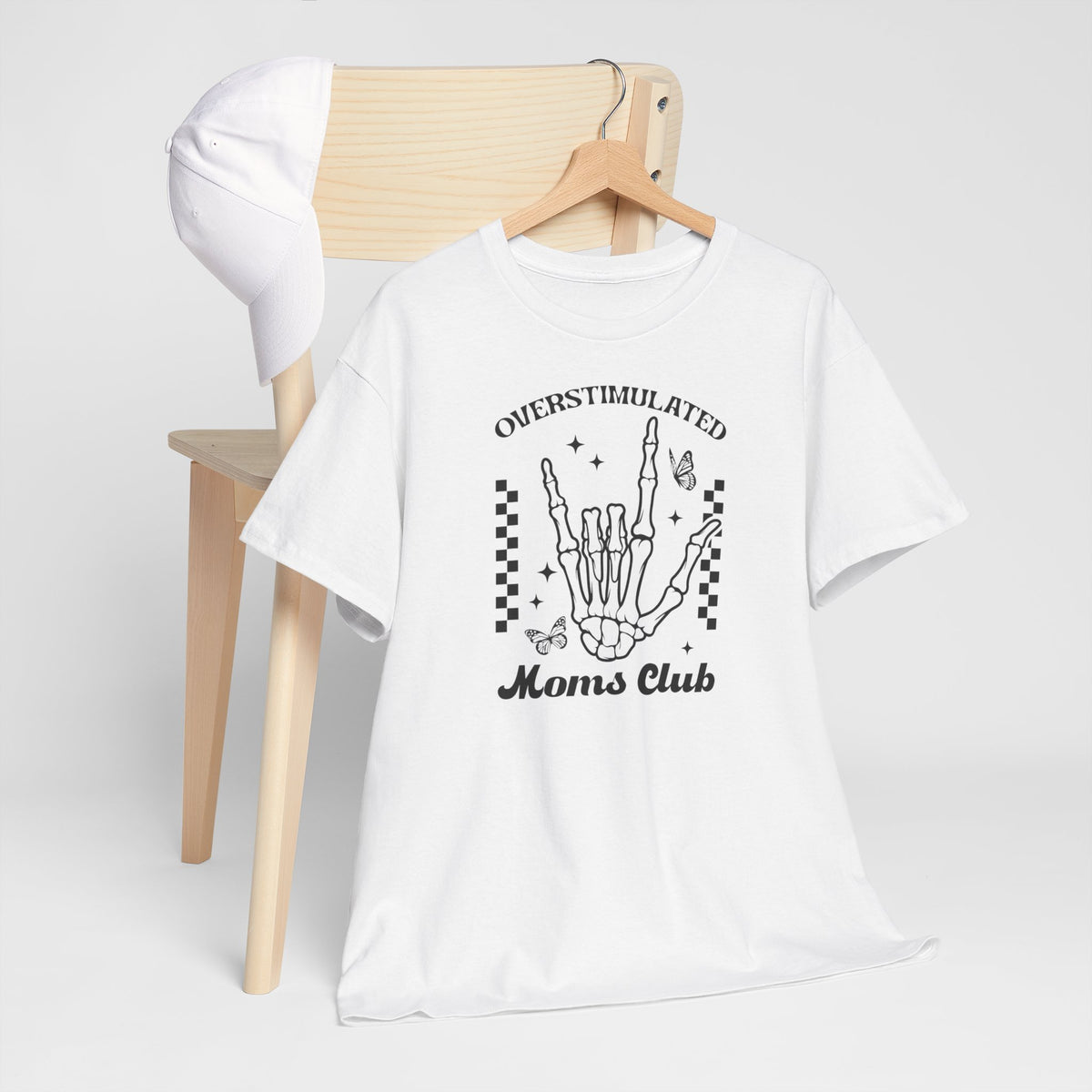 Wit oversized t-shirt op houten kledinghangers met zwarte handillustratie en “Moms Club”