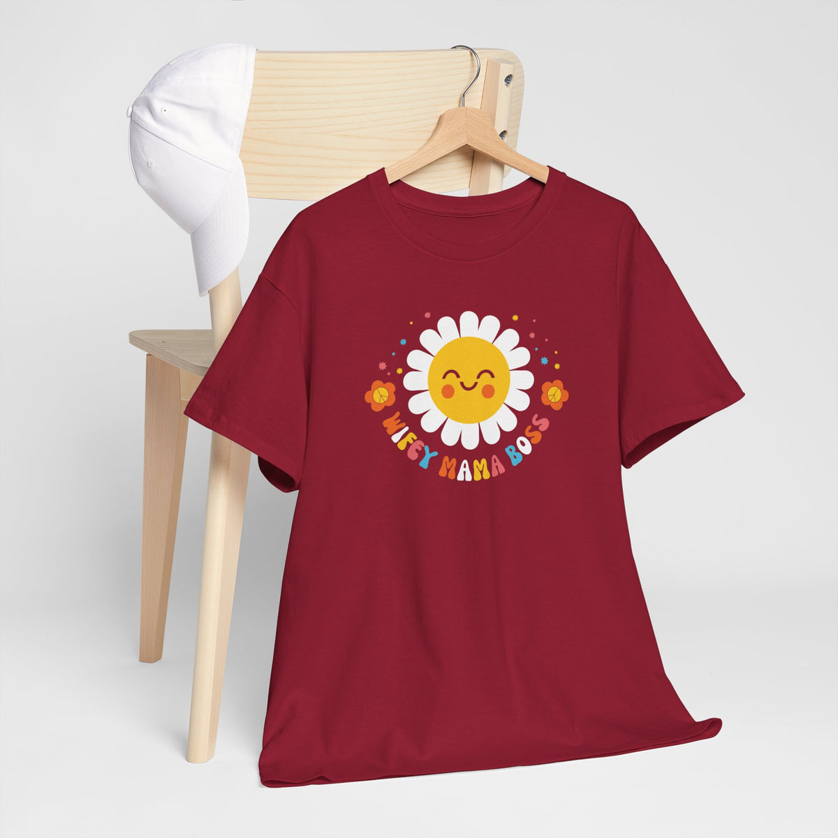 Wijnrode t-shirt met zon- en bloemenprint, plat op een houten standaard