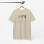 Beige T-shirt met bloemenillustratie en sierlijke namen, opgehangen.