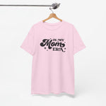 Roze T-shirt aan een houten hanger met borstprint “In my Mom Era”.