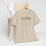 Beige T-shirt met bloemenillustratie en sierlijke namen, opgehangen.