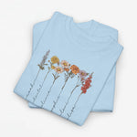 Lichtblauw T-shirt met bloemenillustratie en sierlijke namen langs de bloemenstelen.