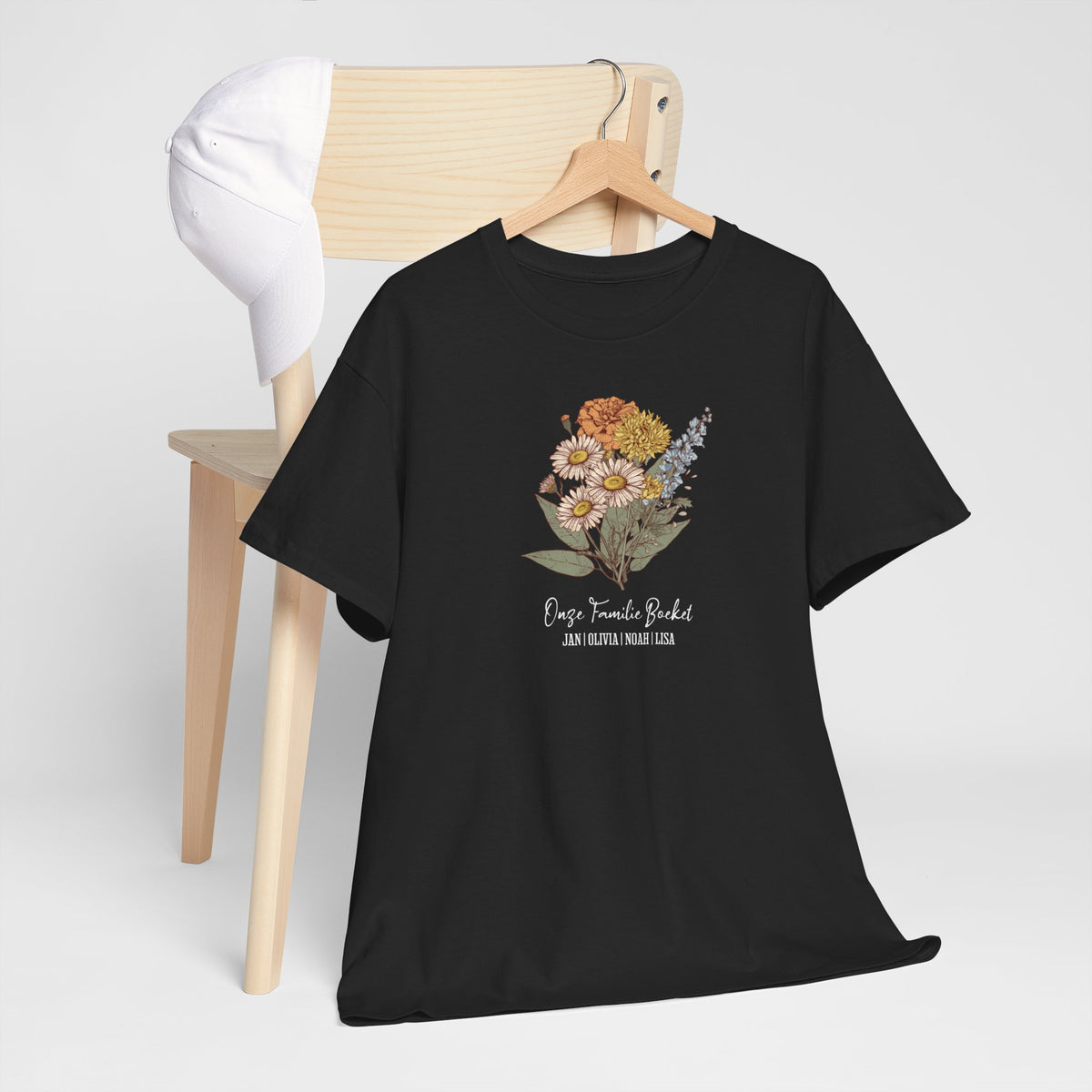 Zwart t-shirt met bloemenboeketprint en tekst, opgehangen aan een houten hanger