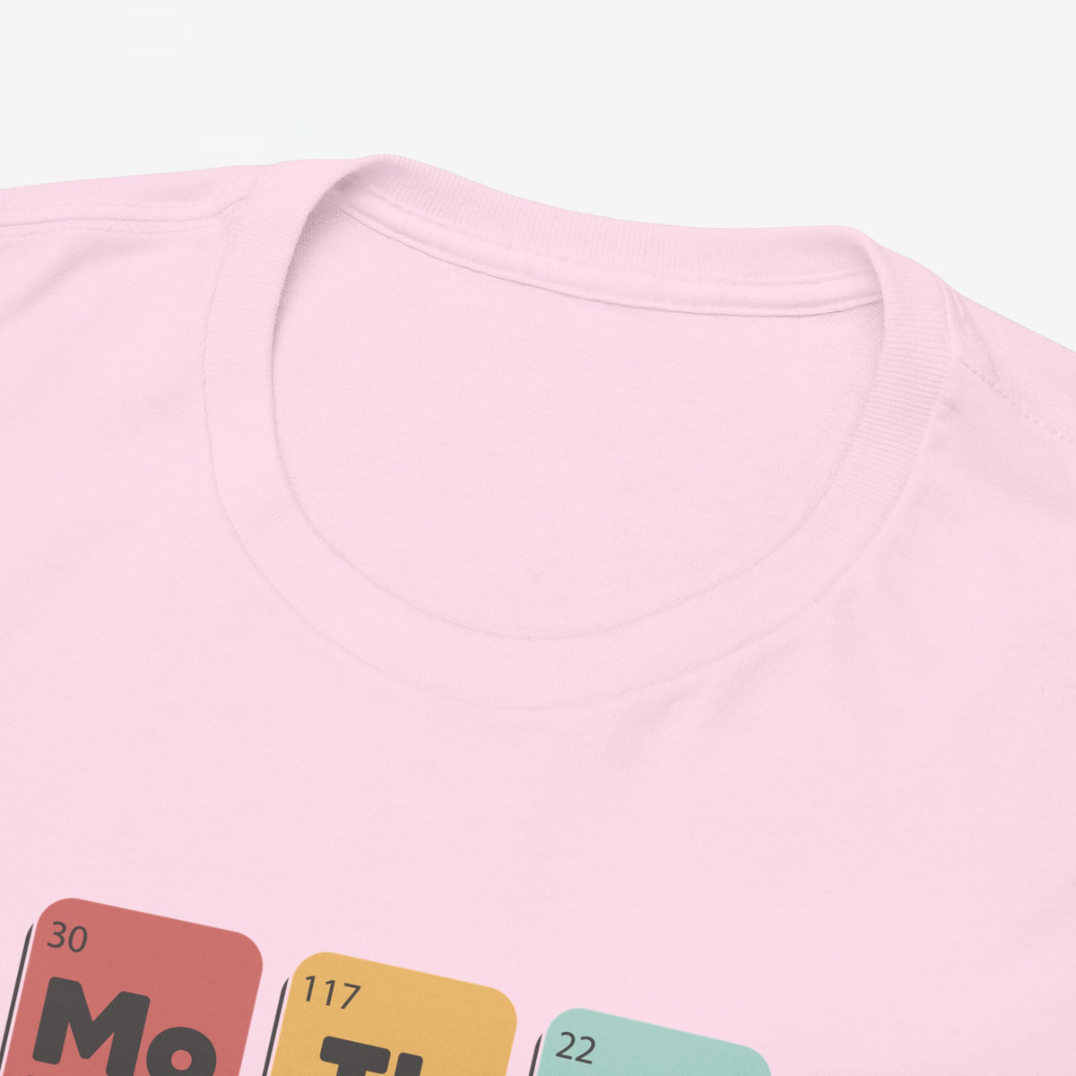 Roze T-shirt close-up: ronde hals en deel van borstprint met gekleurde blokken