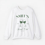 Witte sweater met opdruk “SMIT’S Social Club Zeeland 2024” en wijnglazen.