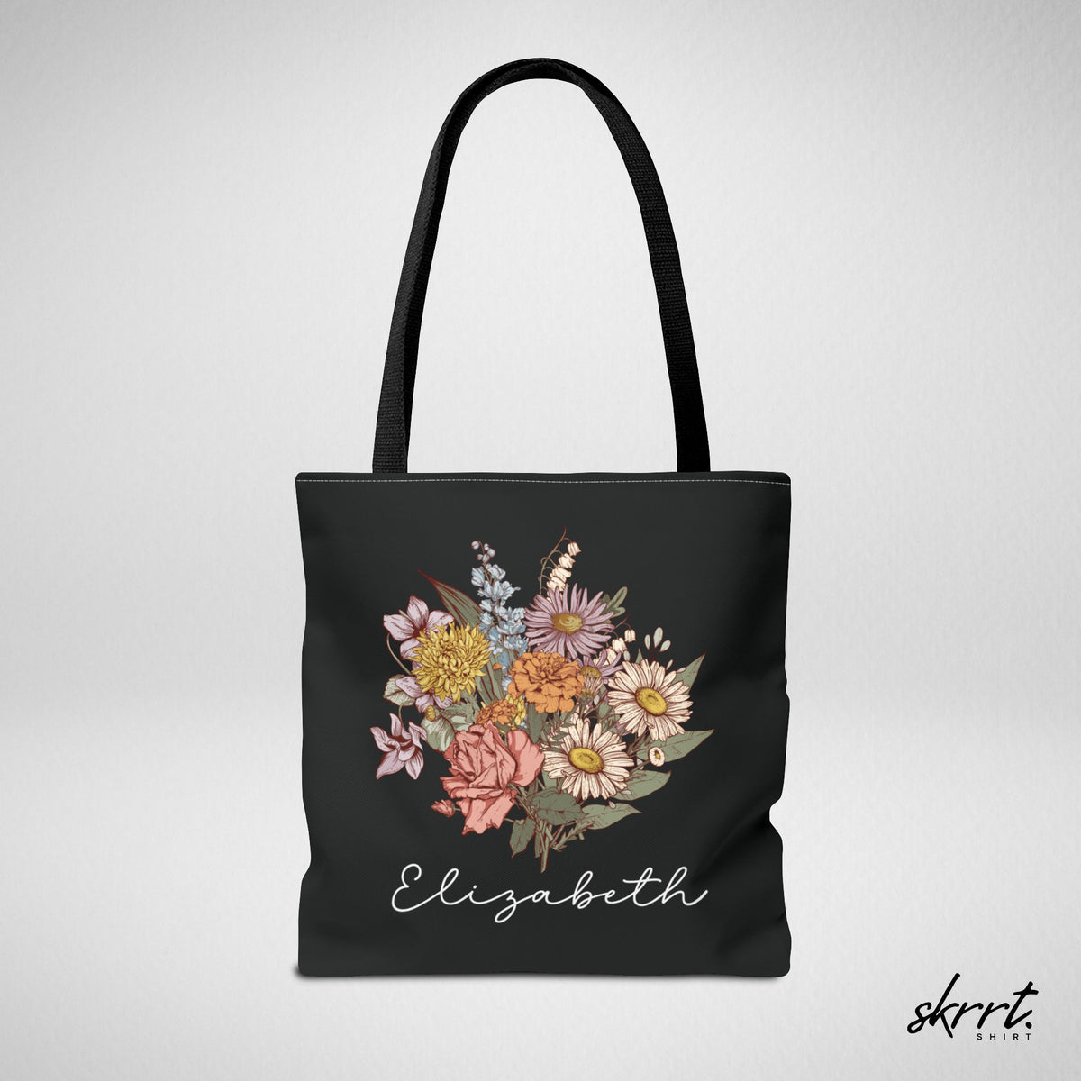 Zwarte tote bag met kleurrijk bloemenboeket en naam Elizabeth, frontaanzicht.