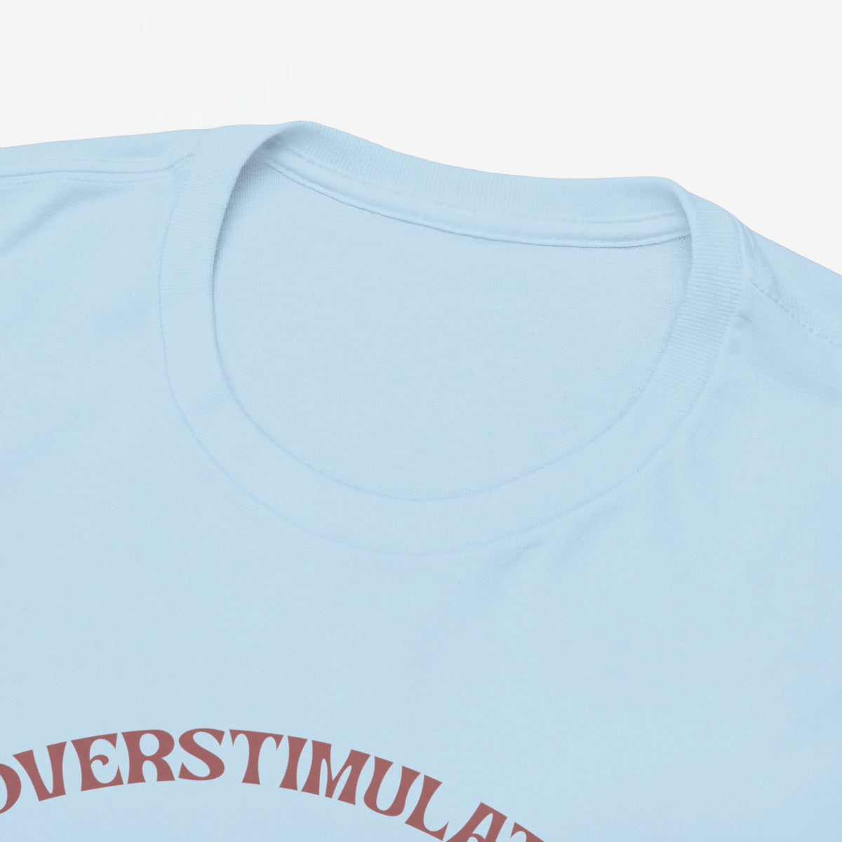 Detail van lichtblauw T-shirt: ronde halsboord en gedeeltelijke borstprint.
