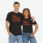 Zwart oversized T-shirt met oranje frontprint 'kan alcohol bevatten', gedragen door twee modellen.
