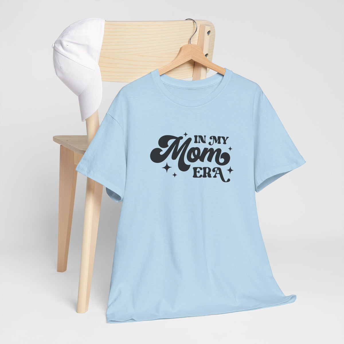 Lichtblauwe t-shirt met zwarte "In My Mom Era"-print op de borst.