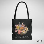 Zwarte tote bag met boeket bloemen en naam Elizabeth in cursief, brede hengsels.