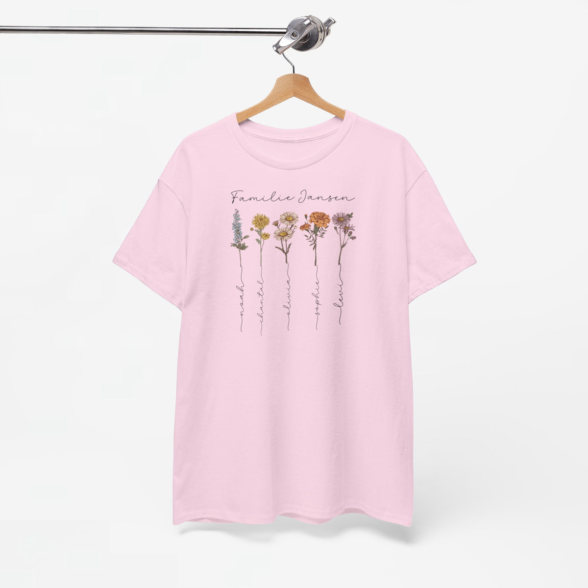 Roze T-shirt op houten hanger met bloemprint en gepersonaliseerde tekst op borst