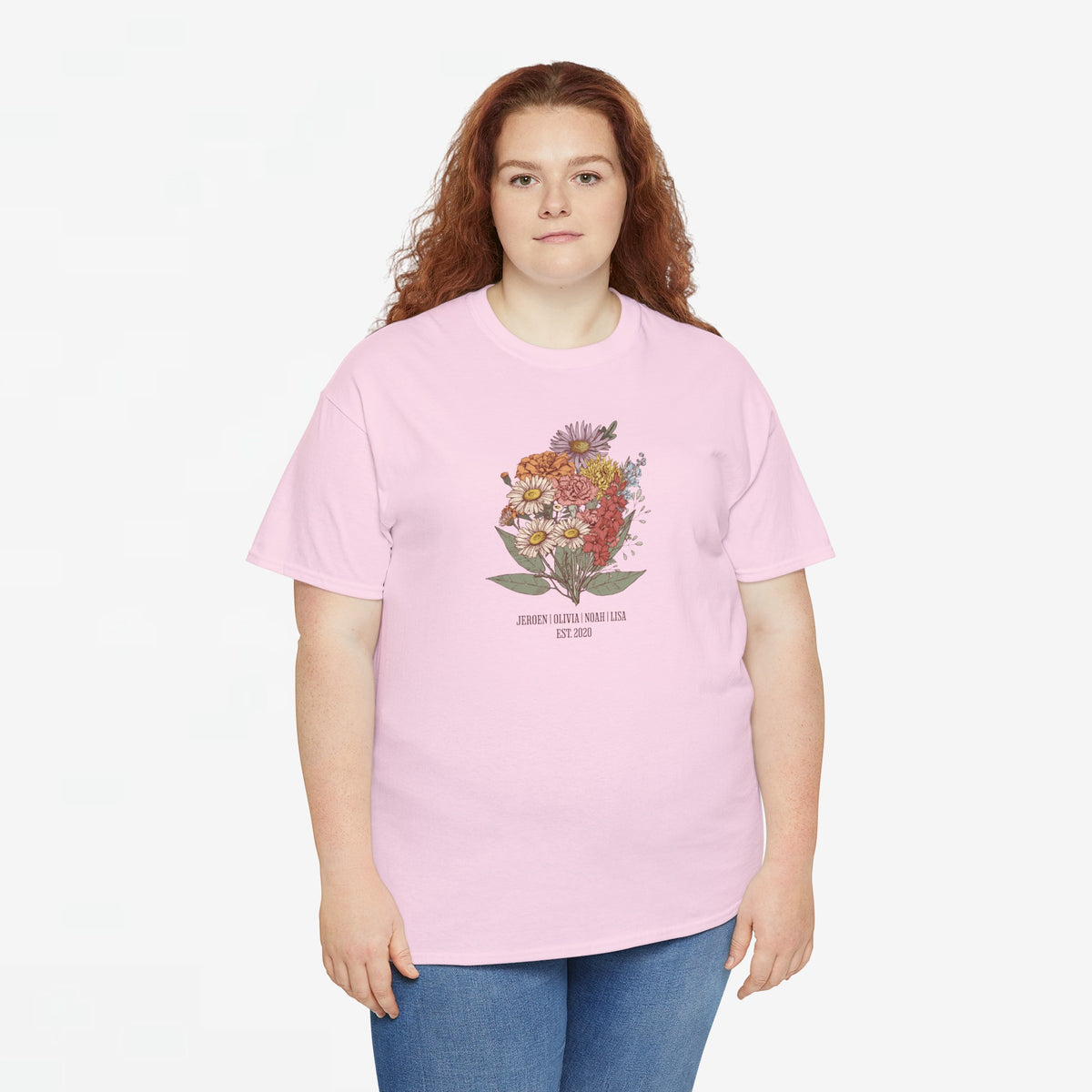 Lichtroze t-shirt met bloemenboeketprint en tekst op de borst, gedragen door model