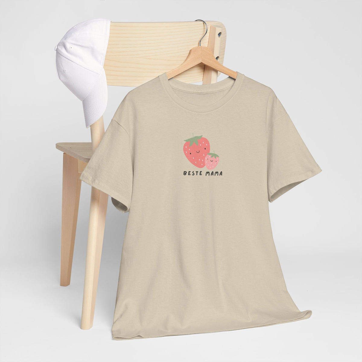Oversized zandkleurige T-shirt op standaard met aardbeienprint en 'Beste Mama'.