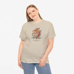 Beige t-shirt met bloemenboeketprint en decoratieve tekst onderaan.