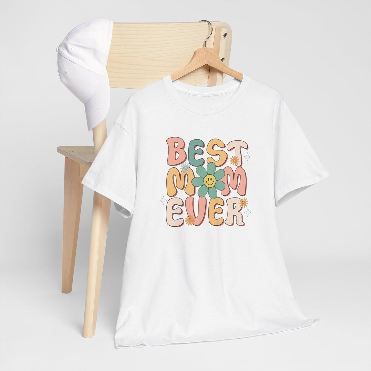 Witte T-shirt met kleurrijke bloemenprint en tekst "BEST MOM EVER" op hanger