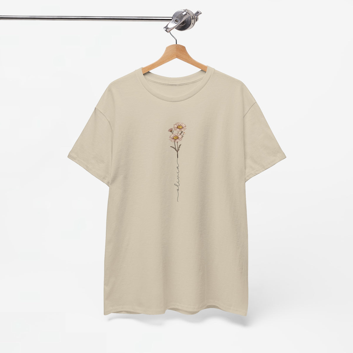 Zandkleurig T-shirt met bloemillustratie op de borst, hangend op houten hanger