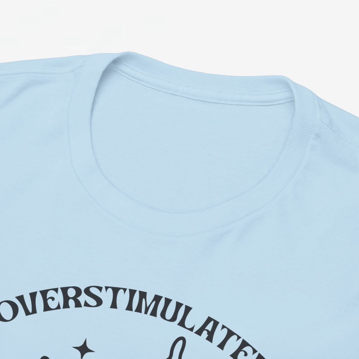 Detail van lichtblauw T-shirthals met deel van “OVERSTIMULATED” tekst
