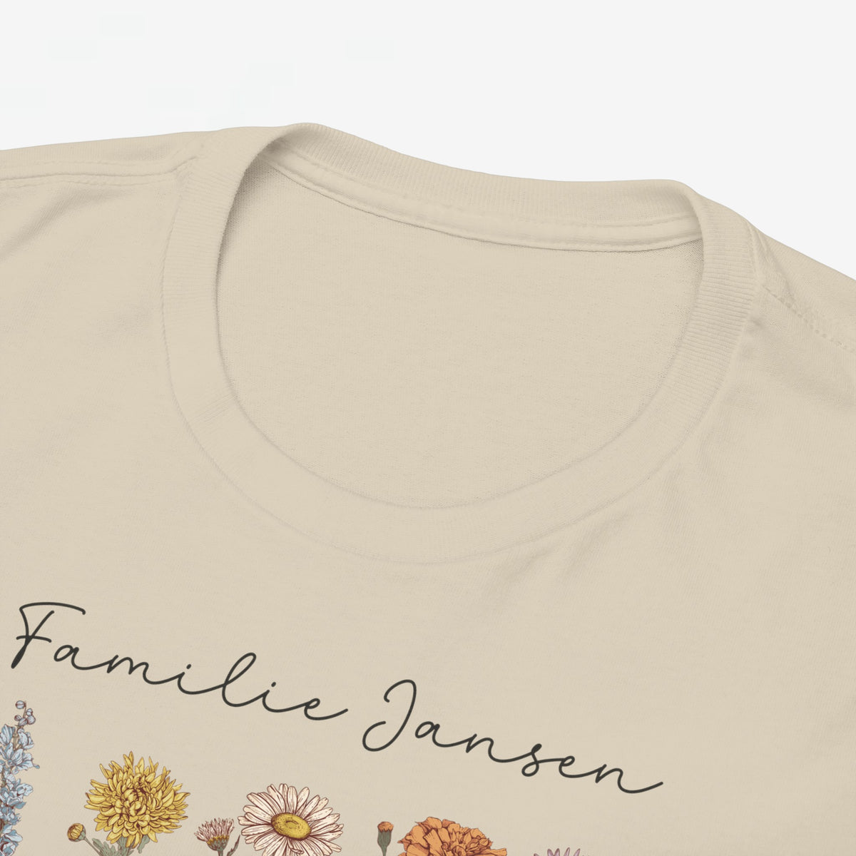 Beige t-shirt close-up met familienaam in sierlettertype en kleurrijke bloemenprint