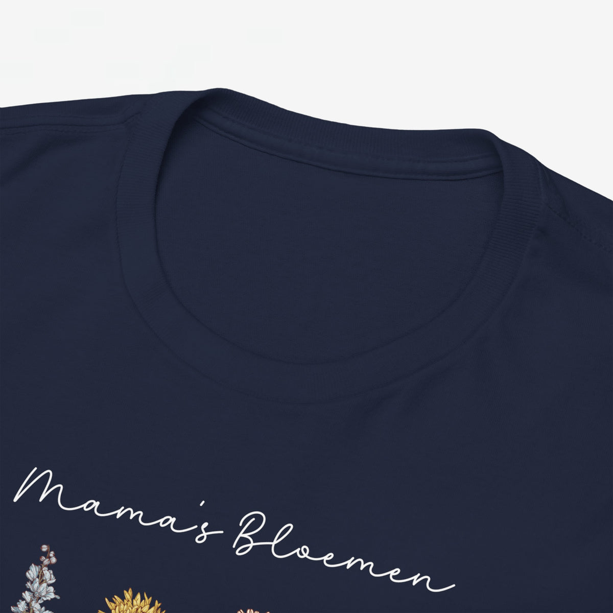 Detail donkerblauwe T-shirt met witte tekst en bloemenprint op de borst