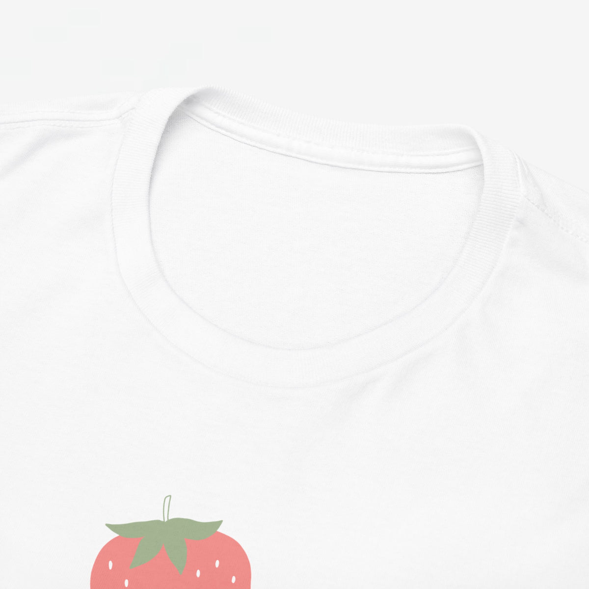 Close-up: witte t-shirt halsboord met aardbei-print en “Beste Mama” onder