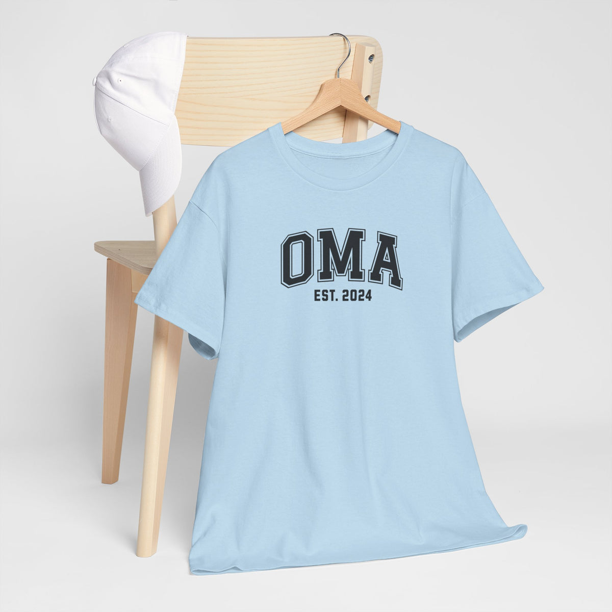 Lichtblauw T-shirt met “OMA” en “EST. 2024” opdruk centraal vooraan.