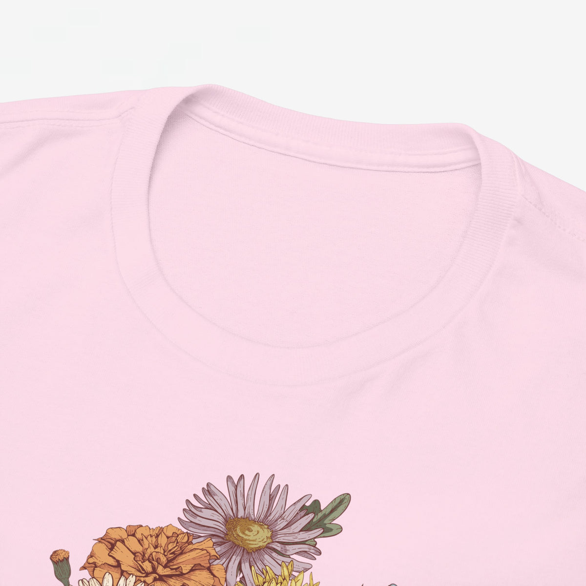 Roze T-shirt close-up: ronde hals en gedeeltelijke bloemenboeketprint onderin