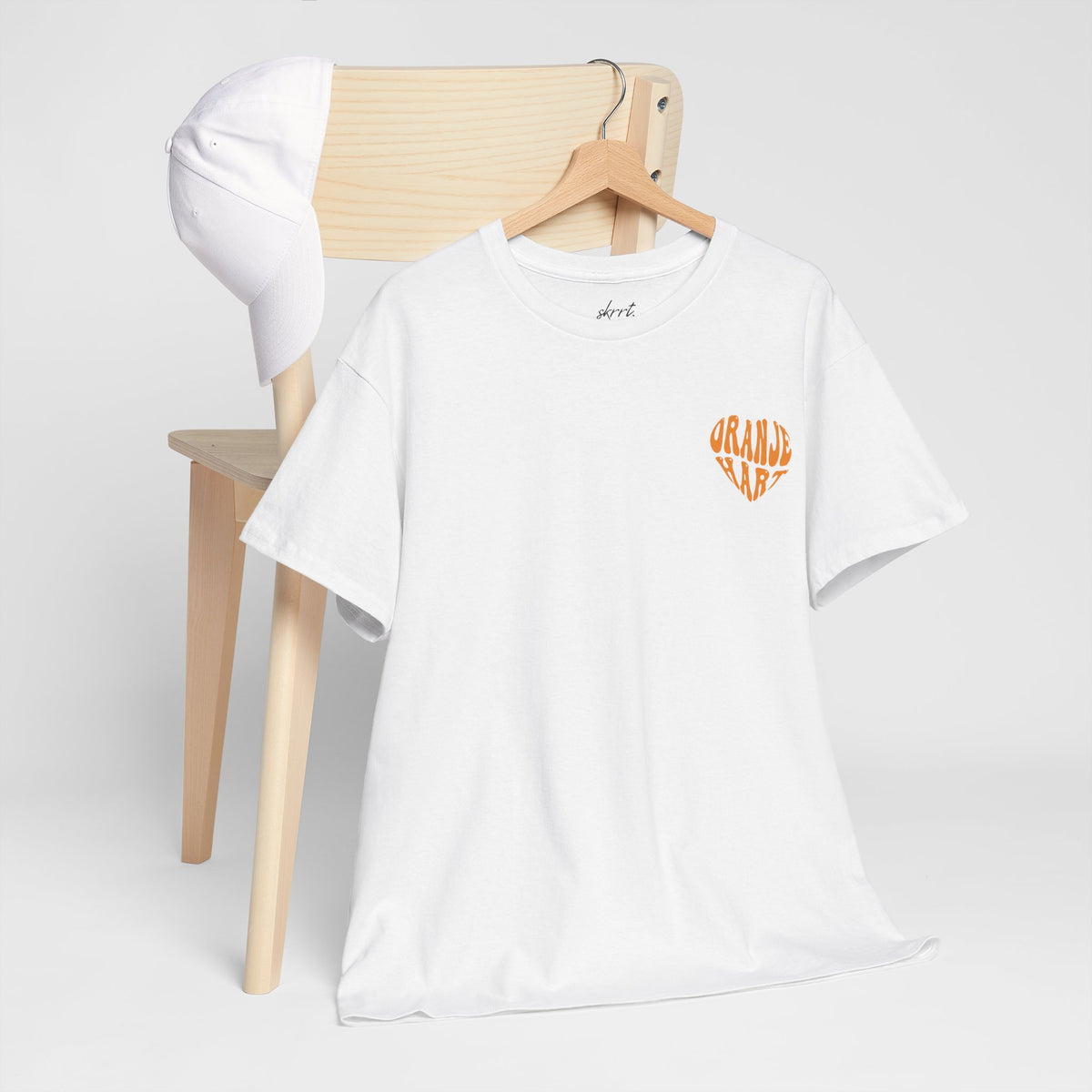 Oversized Koningsdag T-shirt voor dames, witte stof met klein oranje borstlogo op hanger.