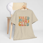 Beige T-shirt met ronde hals en opdruk “Tired Moms Club”, op hangertje.