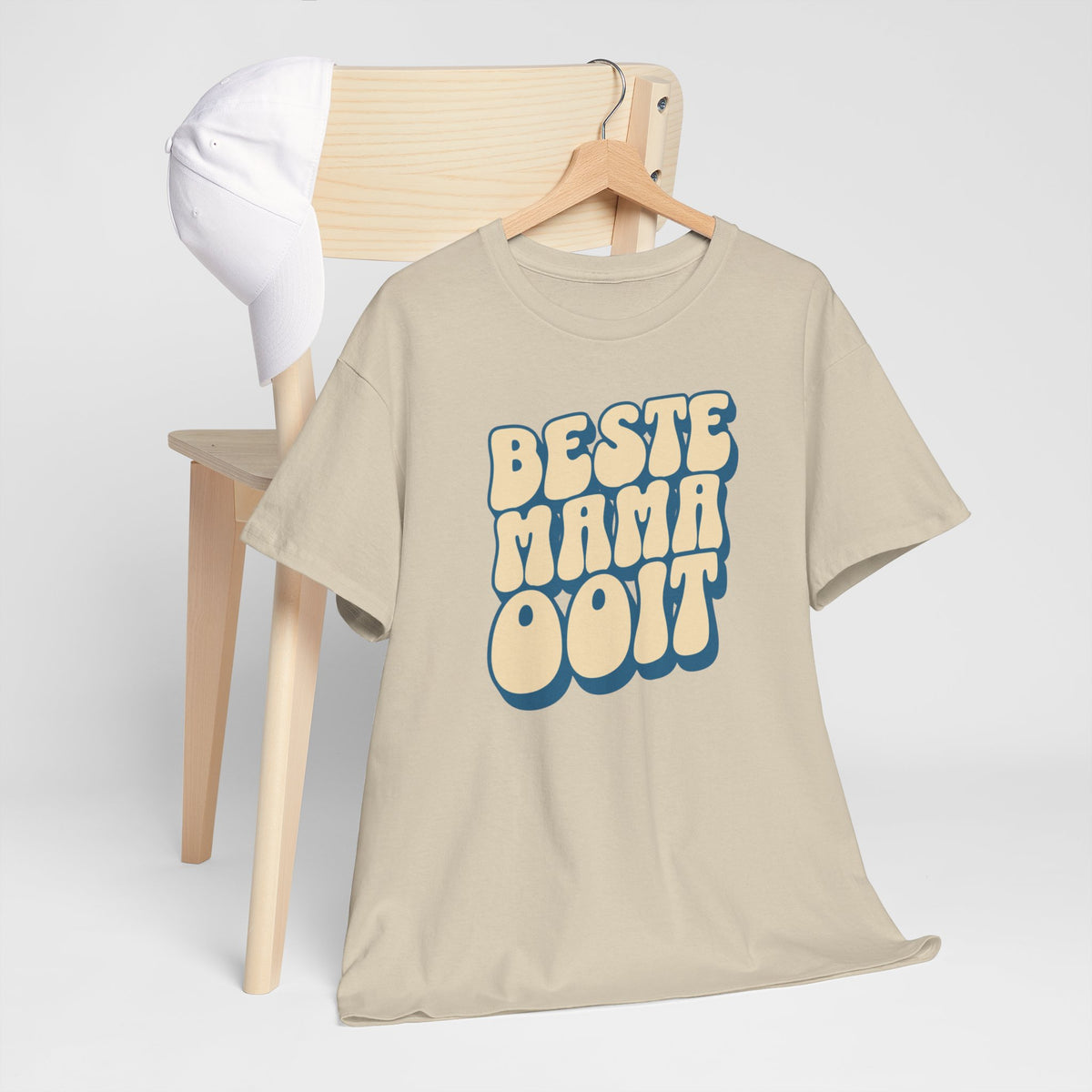 Beige T-shirt met ronde hals en blauwe borstprint, aan houten hanger getoond.