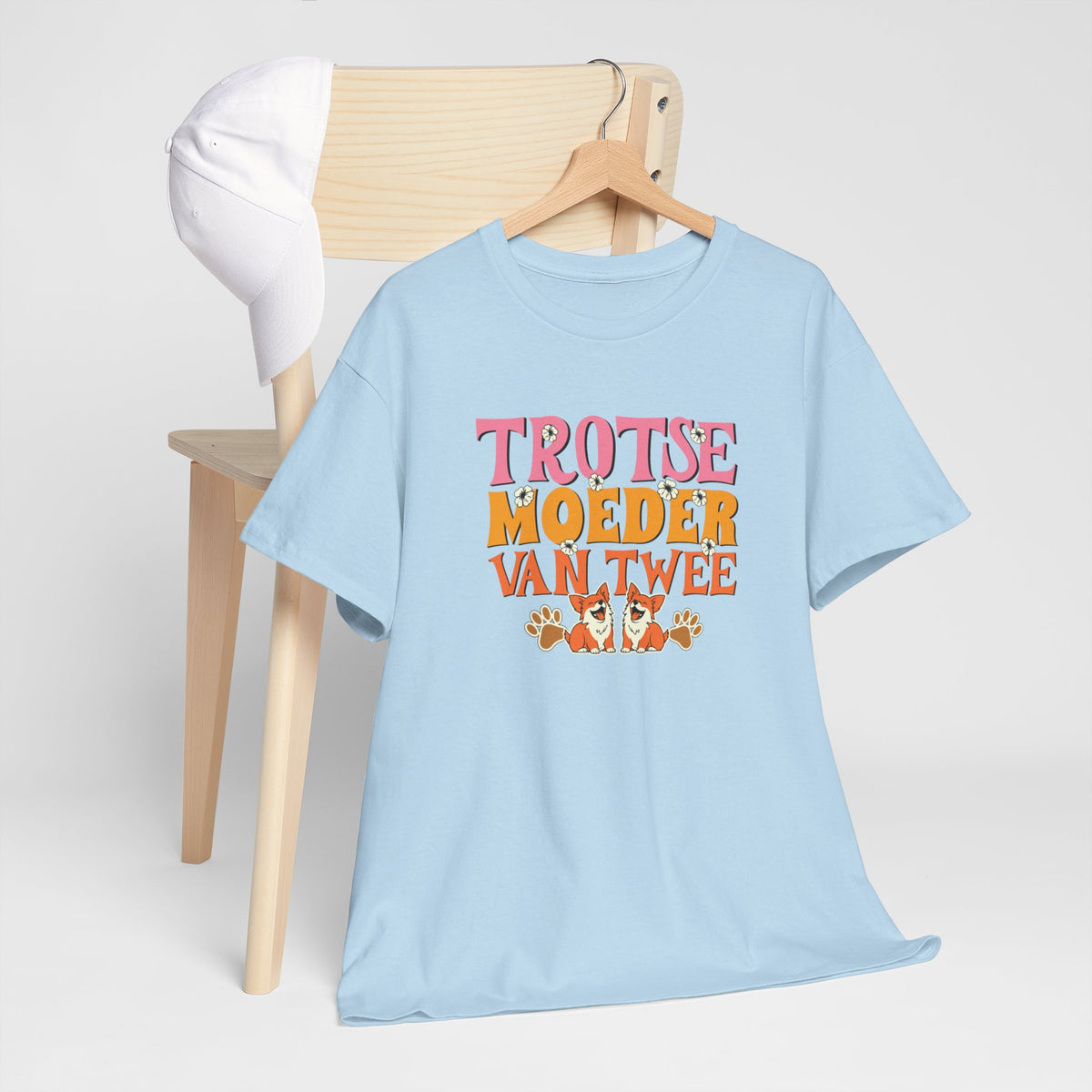 Lichtblauwe T-shirt met ronde hals en gekleurde borstprint, liggend op een stoel.