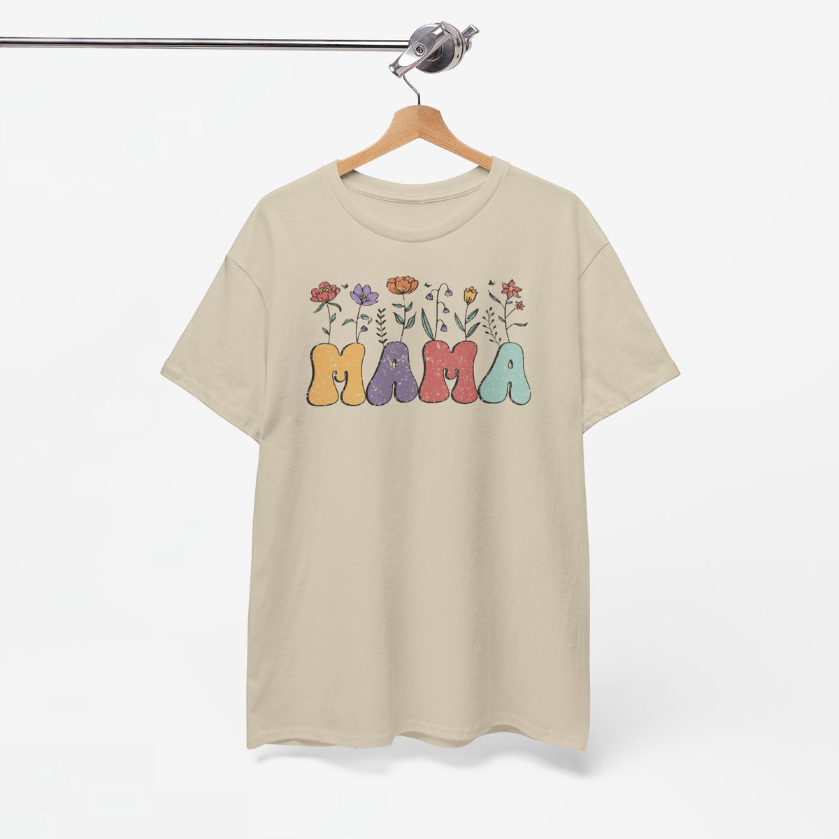 Beige T-shirt met kleurrijke 'Mama' opdruk en bloemen, hangt aan houten hanger.