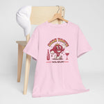 Roze T-shirt op houten hanger met rode stripfiguur- en wijnglasprint