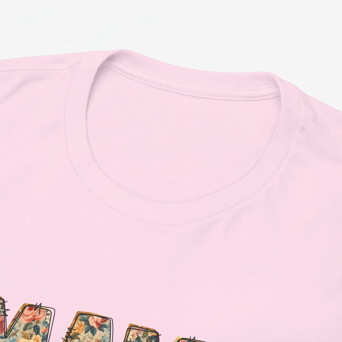 Roze t-shirt met ronde hals; close-up van bovenstuk en rand van “MAMA” print