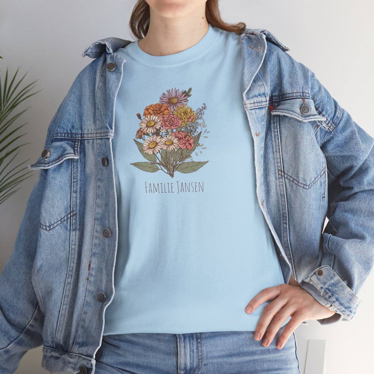Lichtblauw T-shirt met bloemenboeketprint en “FAMILIE JANSEN”, onder jeansjas