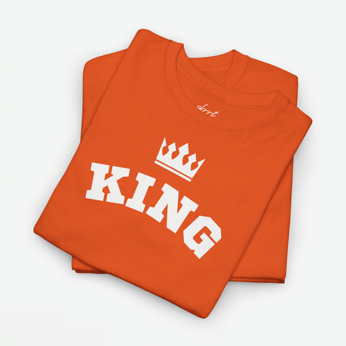Oranje T-shirt met kroon en “KING” op de voorzijde, plat gelegd