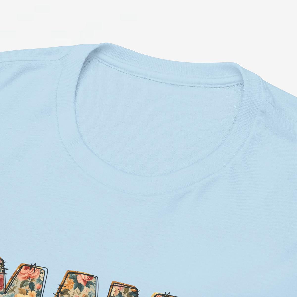 Close-up van lichtblauw T-shirt met ronde hals en bovenrand van 'MAMA' print