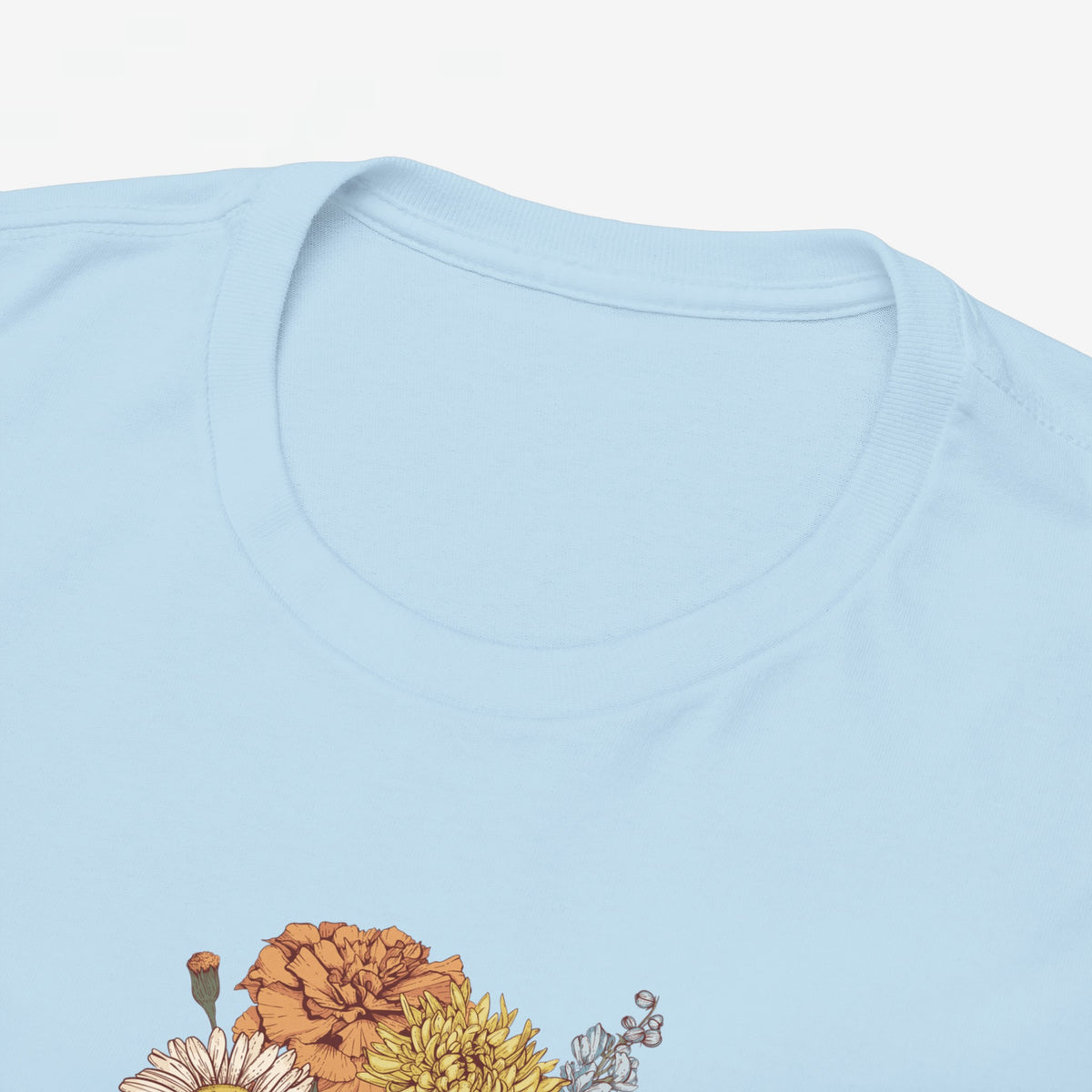 Detail van lichtblauw T-shirt: ronde hals en bovenrand van bloemenprint