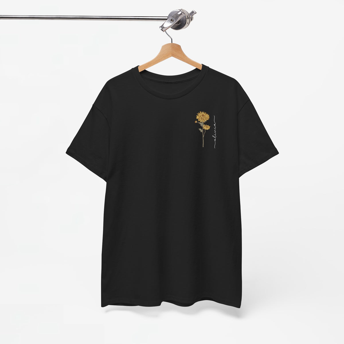 Zwart T-shirt met kleine gele bloemprint op de borst, aan hanger