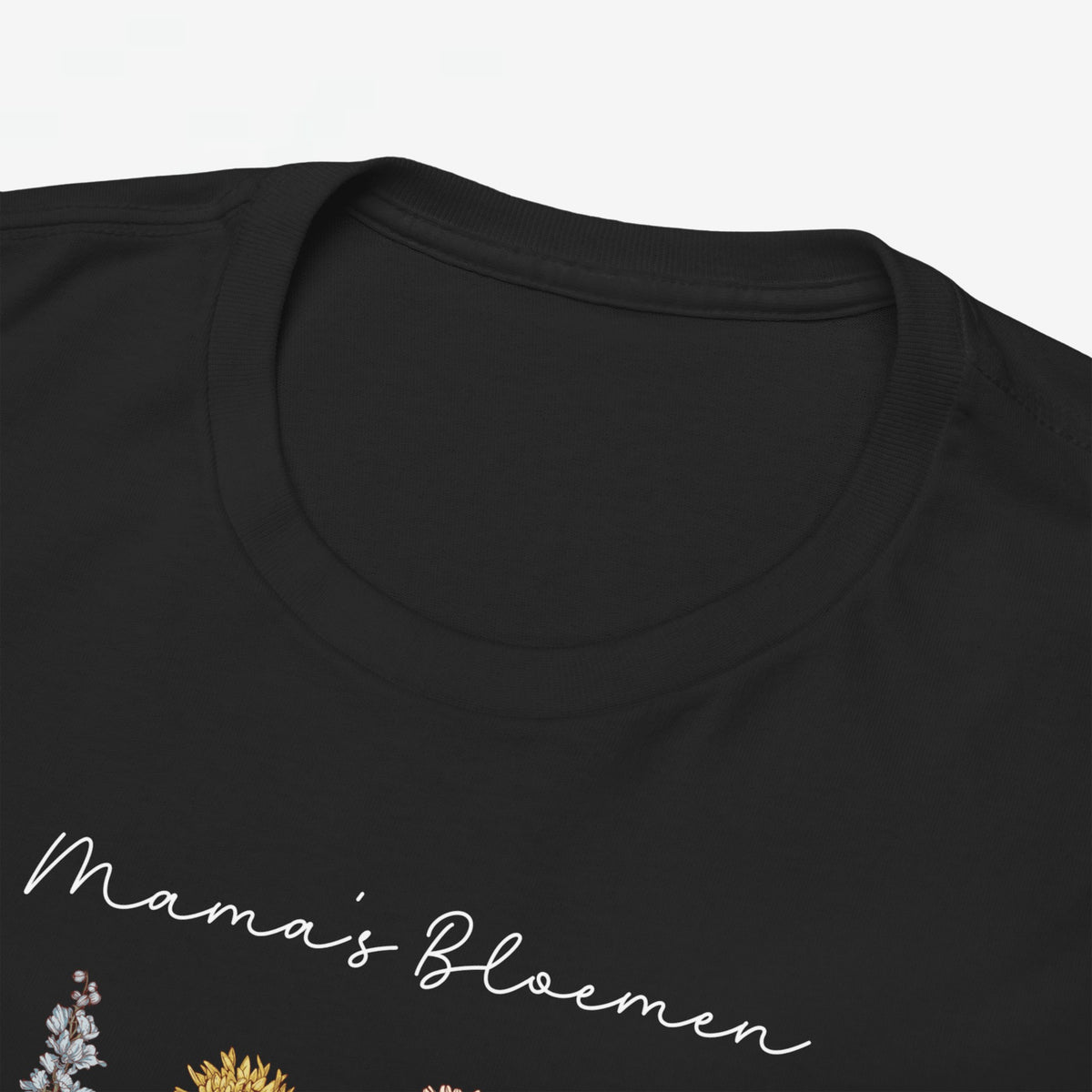 T-shirt zwart met ronde hals en bloemenprint, close-up van bovenstuk en tekst.