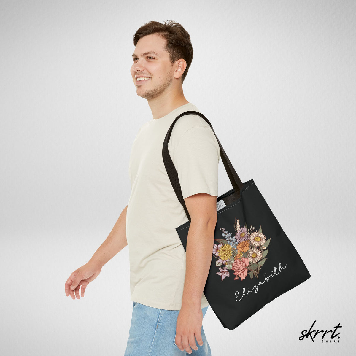 Zwarte tote bag met bloemenboeket en naam, schoudertas gedragen zijaanzicht