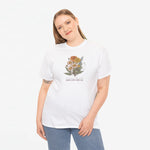 Wit T-shirt met bloemenboeketprint op de borst, gedragen door een vrouw.
